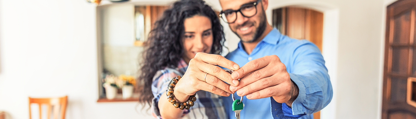 Couple holding new house keys.