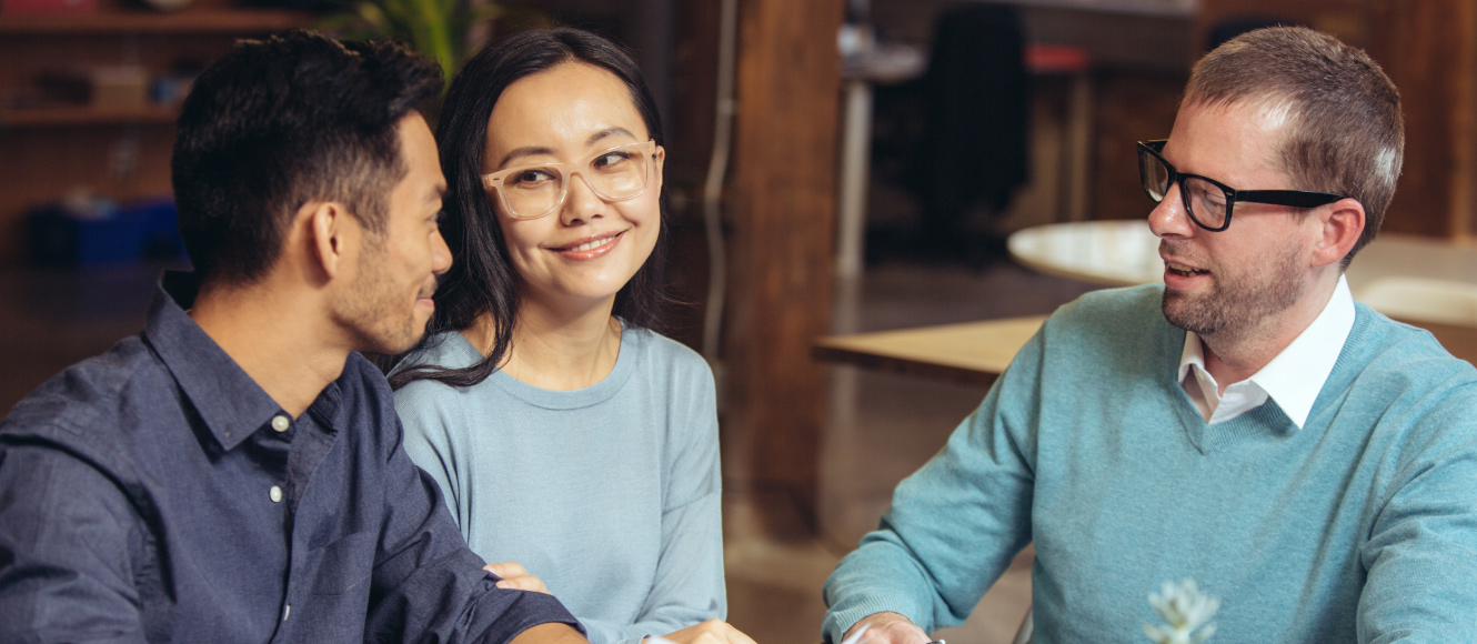 Happy couple speaking with a financial advisor