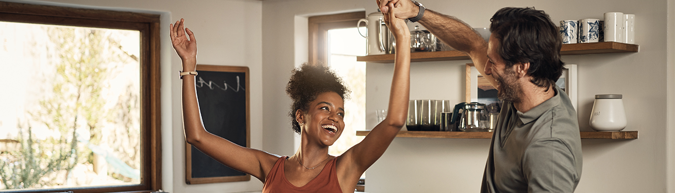 Young couple dancing in the kitchen.