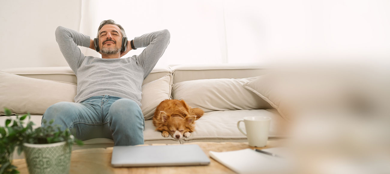Guy on the couch relaxing with his dog. 