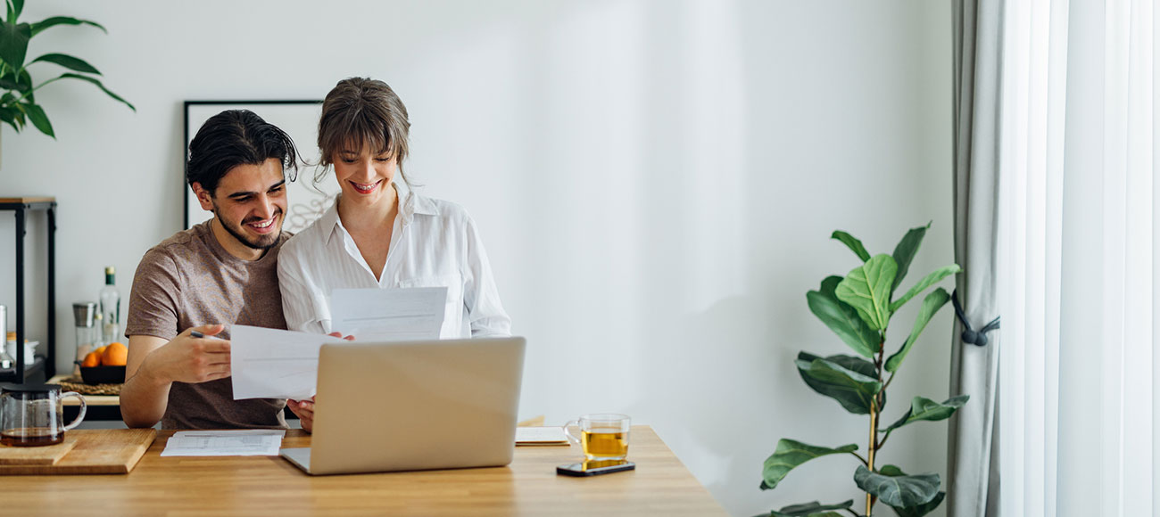Couple reviewing statements in front of a laptop. 