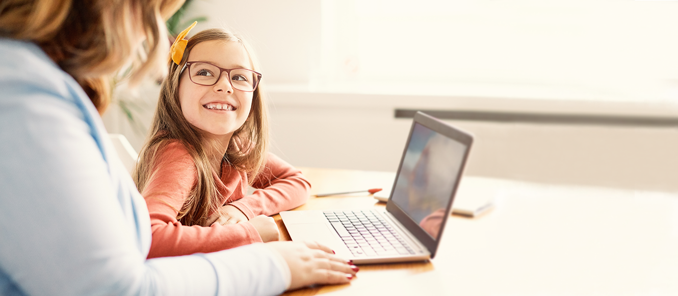 Mother and Daughter smiling at laptop.