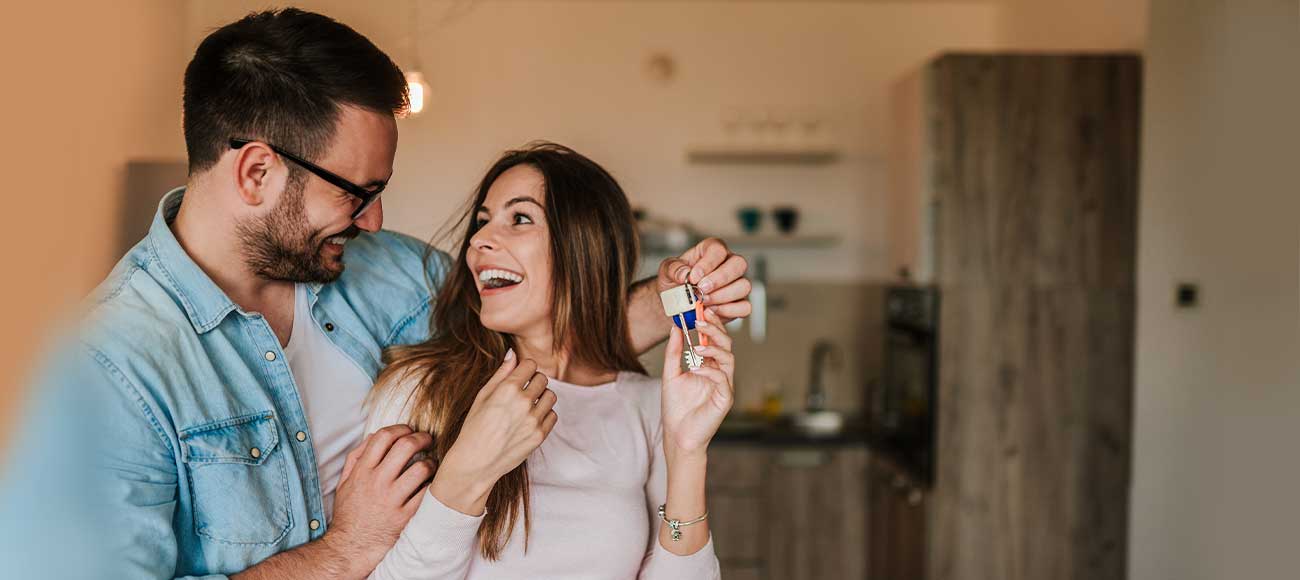 Happy couple with keys to new home.