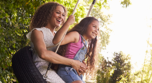 Mother and daughter on tire swing.